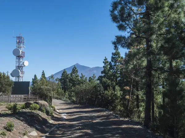 stock image Transmitter, Telecommunications and dirt road at top of Cruz de Gala peak with view on volcano Pico del Teide, Teno mountain range, Tenerife, Canary Islands, Spain, Europe