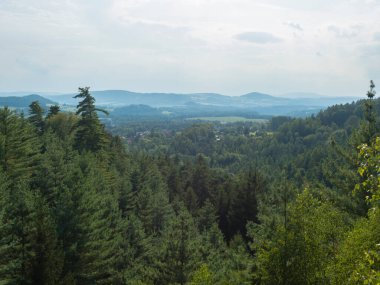 Kumtaşı kaya manzaralı Ponorka 'dan panoramik manzara, Ceska Kamenice kasabası yakınlarındaki 3 kumtaşı kulenin tepesindeki denizaltı. Lusatian Dağları 'ndaki yaz manzarası, yeşil tepeler, meşe ve çam ağacı ormanı