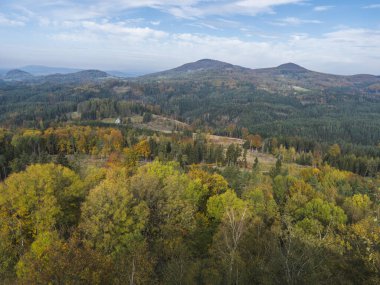 Dolni Prysk yakınlarındaki Stredni Vrch 'den panoramik manzara, Ceska Kamenice. Luzicke azgın Lusatian Dağları, Çek Cumhuriyeti 'nde renkli ormanlar, tepeler ve mavi bulutlu gökyüzü ile sonbahar manzarası