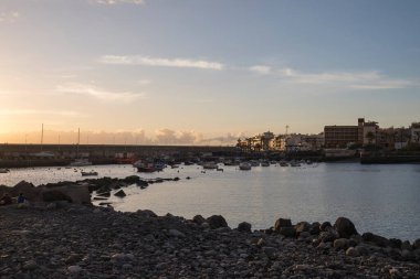 Playa de San Juan Körfezi 'nin altın gün batımı manzarası. Korunan kumsal ve küçük limanı var. Playa de San Juan, Tenerife adasının güneybatısında küçük bir balıkçı köyüdür..