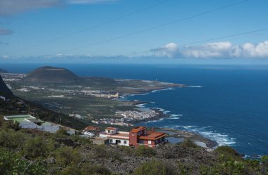 Mirador de Garachico 'daki Garachico kasabasının yakınlarındaki renkli evlerin havadan görünüşü lav kayalarıyla dolu yeşil okyanus manzarası. Popüler turizm merkezi, Tenerife Kanarya Adaları