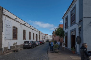 Garachico, Kanarya Adası, Tenerife, İspanya, 02 Şubat 2025: Geleneksel sömürge mimarisi ve güneşli kış gününde yürüyen turistlerle eski Garachico kasabasındaki Paved caddeleri.