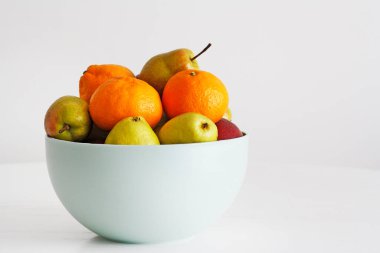 Bir kase dolusu meyve. Elma, armut, portakal.