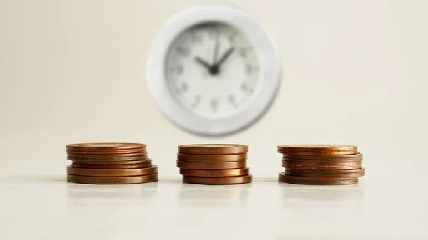 Tax time or time is money are shown using a photo of coins and clock