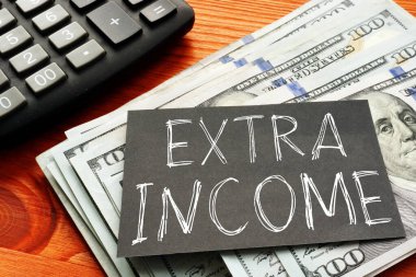 Ekstra gelir, kağıt üzerinde bir metin ve dolar fotoğrafı kullanılarak gösterilir