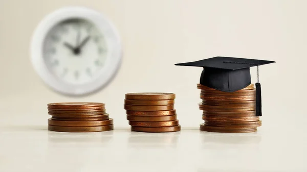 Education costs. Graduation Hat on the coins. Saving every single dollar and cent for higher education.