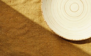 Minimalist estetik nötr doku pankartı, arka planda gölgeli ve düz metin yatağı için boş alanı olan bir tabağın görüntüsünü kapatın. Günlük gıda konseptini azaltmak