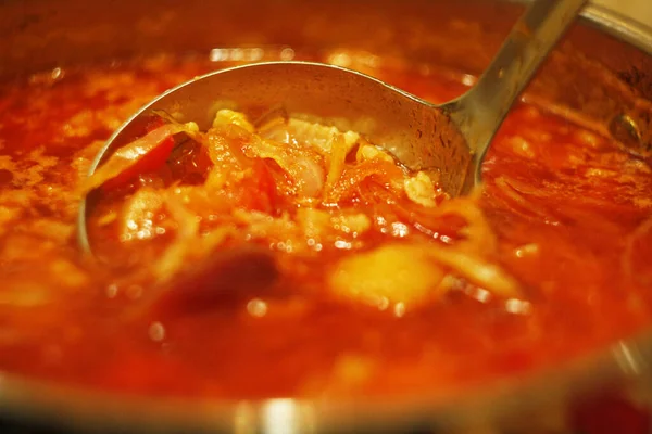 Authentic classic Ukrainian borscht or borsch with beet, tomatoes, beef, lots of vegetables and cabbage. Hot fresh borscht in a pot. Cooking of borscht