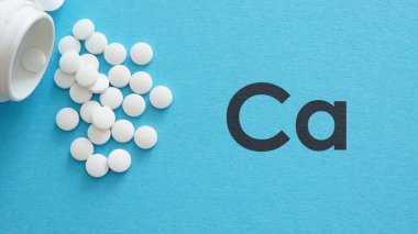 Kemik insan sağlığı için kalsiyum takviyesi. Kalsiyum Sağlık Konsepti. Mavi arkaplanda Ca tabletleri.