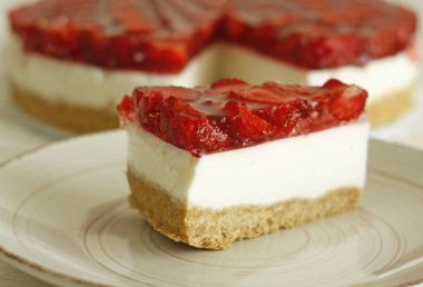 Bir dilim çilek ve jöleli klasik cheesecake dilimi. Çilekle süslenmiş ev yapımı tatlı..