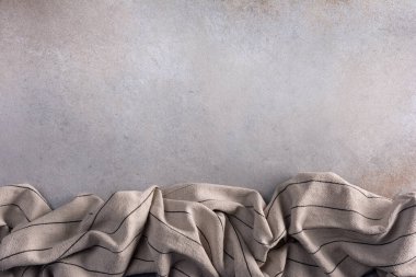 Çizgili keten mutfak koşucusunun üst görüntüsü veya kopyalama alanı olan gri beton zemin üzerindeki havlu