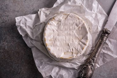 Krem peynirin ya da camembert peynirinin üst görüntüsü, gri beton arka planda pişirmek için lezzetli bir yemek.