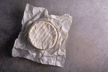 Krem peynirin ya da camembert peynirinin üst görüntüsü, gri beton arka planda pişirmek için lezzetli bir yemek.