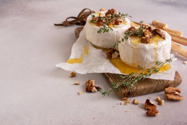 Lezzetli bir akşam yemeği için beyaz brie peyniri ya da kekik, ceviz, bal ve Grissini ekmek çubuğu ile camembert peyniri.