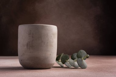 Modern candle in grey concrete with green plant eucalyptus for relax, cozy interior design, loft