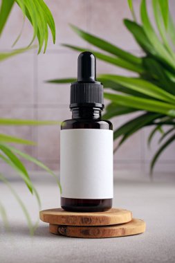 Serum bottle with white mockup label for cosmetic design. Minimal product display scene for serum or essence with brown glass dropper bottle. 