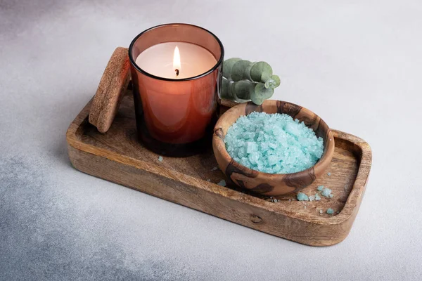 蓝色海盐在木制碗里 配有蜡烛和桉树 用于灰色混凝土背景上的放松 — 图库照片