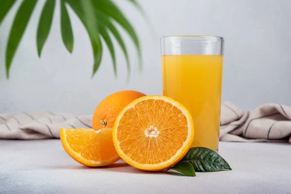 Chutný Čerstvý Pomerančový Džus Skle Nakrájeným Pomerančem Listy Šedém Betonovém — Stock fotografie
