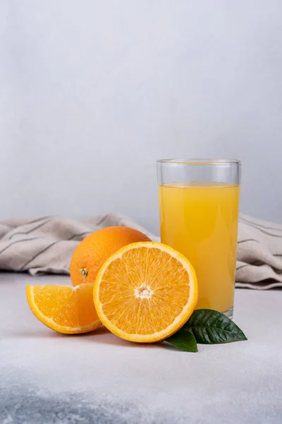 Ízletes Friss Narancslé Üvegben Szeletelt Narancs Levelek Szürke Beton Háttér — Stock Fotó