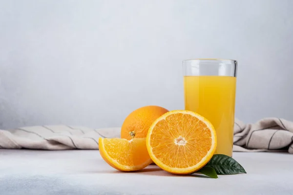 Ízletes Friss Narancslé Üvegben Szeletelt Narancs Levelek Szürke Beton Háttér — Stock Fotó