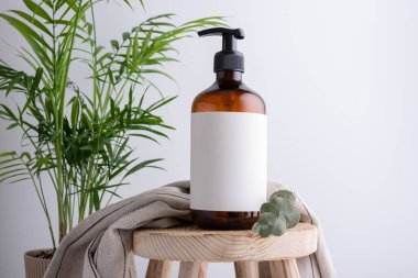 Duş jeli, sıvı sabun ya da banyodaki ahşap taburede şampuan olan çevre dostu kahverengi şeker kutusu.