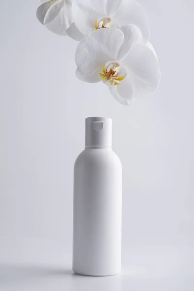 Champú Cosmético Blanco Maqueta Botella Loción Con Orhid Blanco Sobre —  Fotos de Stock