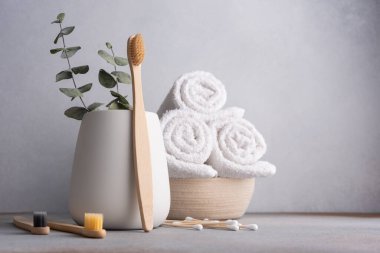 Doğal çevre dostu bambu diş fırçası ve beyaz banyo havluları.