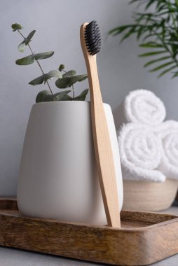 Doğal çevre dostu bambu diş fırçası ve beyaz banyo havluları.