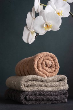 Pamuklu havlular ve beyaz orkide çiçekleri. Banyo ve refah hala hayat.