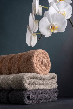 Pamuklu havlular ve beyaz orkide çiçekleri. Banyo ve refah hala hayat.