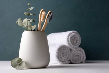 Beyaz bir kabın içinde çevre dostu bambu diş fırçaları. Sıfır atık, plastiksiz, sürdürülebilir yaşam tarzı konsepti.