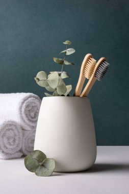 Beyaz bir kabın içinde çevre dostu bambu diş fırçaları. Sıfır atık, plastiksiz, sürdürülebilir yaşam tarzı konsepti.