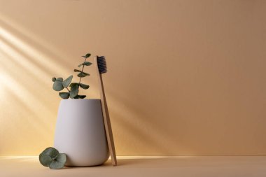 Beyaz bardakta çevre dostu bambu diş fırçası. Sıfır atık, plastiksiz, sürdürülebilir yaşam tarzı konsepti.