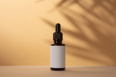 Kahverengi kozmetik şişesi. Palmiye yapraklarının gölgesi var. Doğal organik kozmetik ürünleri için şablon.