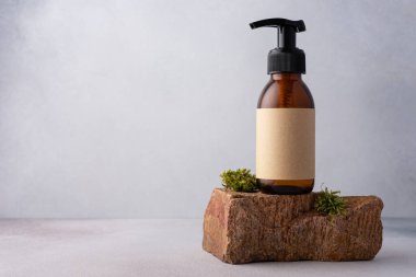 Kozmetik ürünler için yosun taşının üzerinde duran kahverengi cam şişe maket. Doğal organik kozmetik konsepti