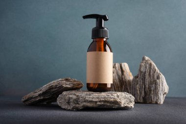 Taş bir podyumda, karanlık bir arka planda cam pompa şişesini taklit et. Kozmetoloji, kaplıca tedavisi konsepti.