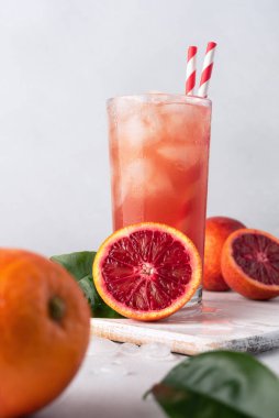 Buzlu içecek. Kırmızı veya kan Sicilya portakal suyu bardakta ve taze portakallarda. 