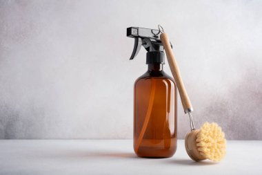 Tek kehribar kahverengi sprey şişe ve bulaşık fırçası. Çevre dostu ve sürdürülebilir yaşam tarzı için mutfak temizleme ürünleri. 