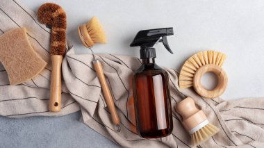 Kehribar sabun şişesi ve ahşap bulaşık fırçasıyla çevre dostu temizlik seti. Sürdürülebilir ev bakımı kavramı.