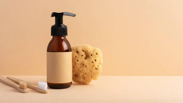 Brown glass bottle with a sea sponge on a yellow background. Concept for a natural bath and skincare product.