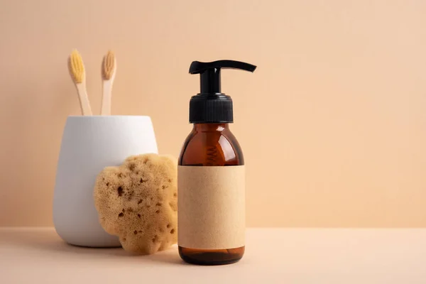 Brown glass bottle with a sea sponge on a yellow background. Concept for a natural bath and skincare product.