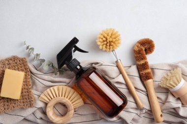Kehribar sabun şişesi ve ahşap bulaşık fırçasıyla çevre dostu temizlik seti. Sürdürülebilir ev bakımı kavramı.