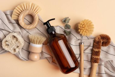 Sürdürülebilir yaşam tarzı için çevre dostu temizlik araçları. Dispanser şişesi, lif süngeri ve eko tabak fırçası..