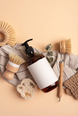 Sürdürülebilir yaşam tarzı için çevre dostu temizlik araçları. Dispanser şişesi, lif süngeri ve eko tabak fırçası..