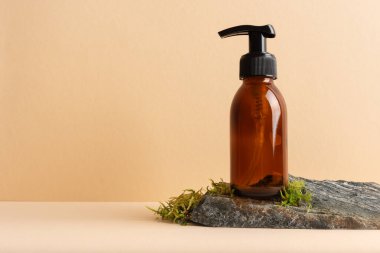 Bej arka planda yosun taşı bir podyumda cam pompa şişesini taklit et. Kozmetoloji, kaplıca tedavisi konsepti.