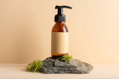 Bej arka planda yosun taşı bir podyumda cam pompa şişesini taklit et. Kozmetoloji, kaplıca tedavisi konsepti.