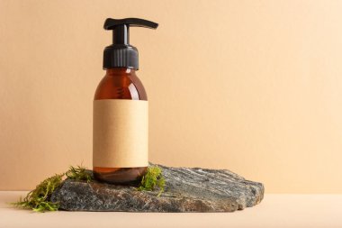 Bej arka planda yosun taşı bir podyumda cam pompa şişesini taklit et. Kozmetoloji, kaplıca tedavisi konsepti.