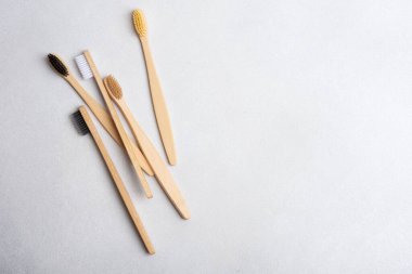 Gri arka planda çevre dostu bambu diş fırçaları. Doğal organik banyo güzellik ürünü konsepti. 