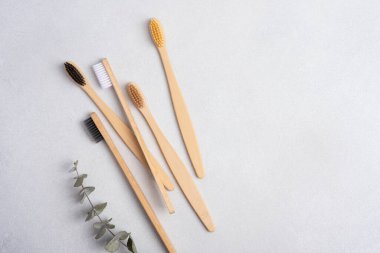 Gri arka planda çevre dostu bambu diş fırçaları. Doğal organik banyo güzellik ürünü konsepti. 