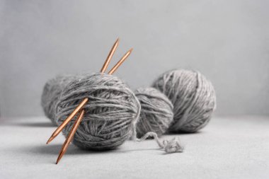 Ahşap örgü iğneli gri iplik topları. İğne işi ve eğlence konsepti.